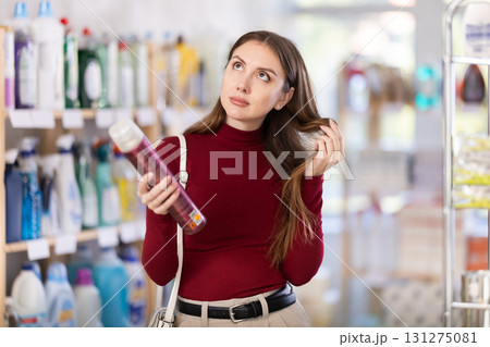 Young woman choosing hairspray in store 131275081
