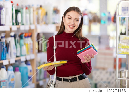 Young woman chooses sponges and rags in store Young woman chooses sponges and rags in store 131275128
