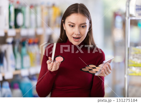 Young woman choosing blush and sculptor in store Young woman choosing blush and sculptor in store 131275184