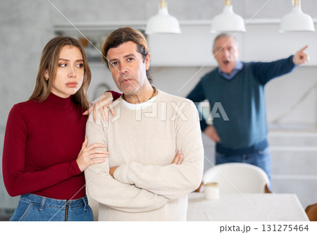 Elderly father scolds and shouts at a married couple. Quarrel in home kitchen Elderly father scolds and shouts at a married couple. Quarrel in home kitchen 131275464