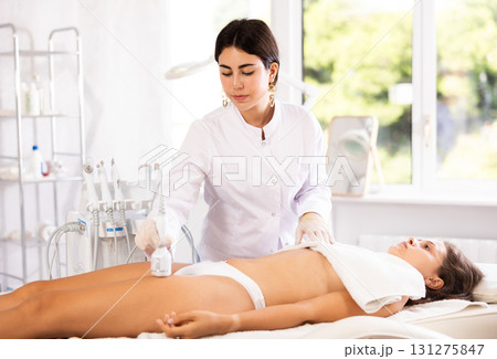 female doctor making hip beauty procedure with ice hummer 131275847