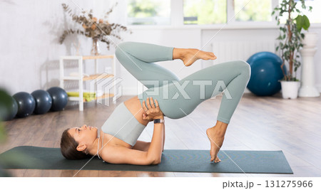 Experienced girl fitness club teacher performs setu bandha sarvangasana Experienced girl fitness club teacher performs setu bandha sarvangasana 131275966