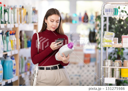 Young woman scanning qr code for detergent Young woman scanning qr code for detergent 131275986