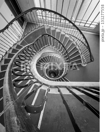 Spiral staircase viewed from above creates dramatic black and white architectural composition Spiral staircase viewed from above creates dramatic black and white architectural composition 131277558