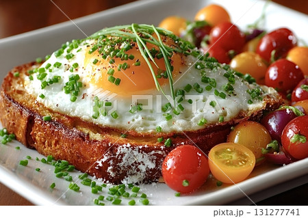 Fried egg on toasted bread with cherry tomatoes and chives Fried egg on toasted bread with cherry tomatoes and chives 131277741