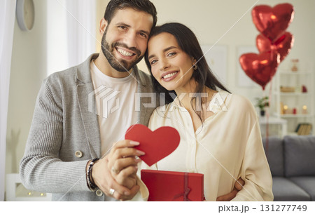 Portrait Of A Happy Couple Holding A Heart Celebrating Valentines Day At Home Portrait Of A Happy Couple Holding A Heart Celebrating Valentines Day At Home 131277749