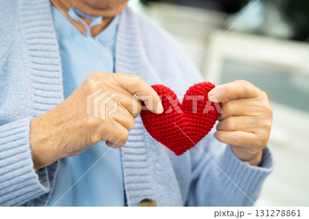 Asian elder senior woman patient holding red heart in hospital. 131278861