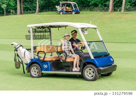 ゴルフ場でゴルフカートに乗るゴルファーの男女 131279596