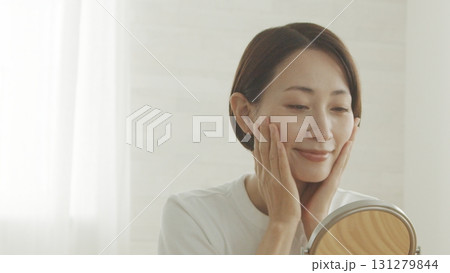 鏡を見ながら肌の調子を確認する40代日本人女性 131279844