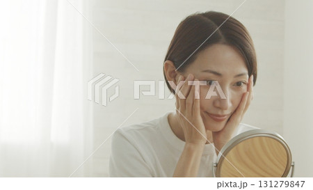 鏡を見ながら肌の調子を確認する40代日本人女性 131279847