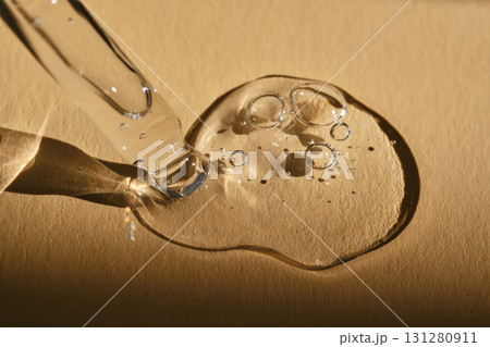 A pipette with cosmetic serum on a beige background. A pipette with cosmetic serum on a beige background. 131280911
