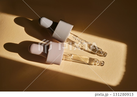 Two pipettes with serum on a beige background. Two pipettes with serum on a beige background. 131280913