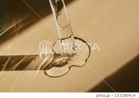 A pipette with cosmetic serum on a beige background. 131280914