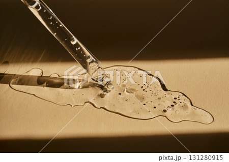 A pipette with cosmetic serum on a beige background. A pipette with cosmetic serum on a beige background. 131280915