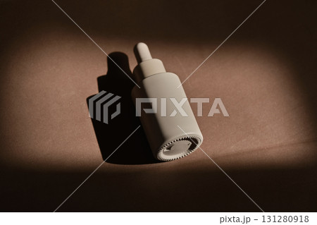 A bottle of face serum on a brown chocolate background. 131280918