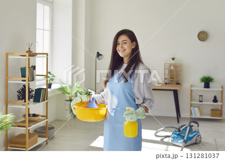 Woman housewife with cleaning tools standing in living room and looking at camera. 131281037