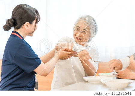 介護施設でスプーンを使い操作訓練, 食事の機能訓練をするシニア女性と作業療法士の女性スタッフ 介護施設でスプーンを使い操作訓練, 食事の機能訓練をするシニア女性と作業療法士の女性スタッフ 131281541