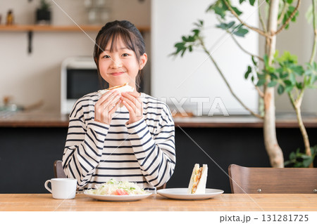 ダイニングでパン,サンドイッチを食べる小学生の女の子,子供 ダイニングでパン,サンドイッチを食べる小学生の女の子,子供 131281725