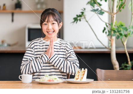 ダイニングでパン,サンドイッチを食べる小学生の女の子,子供(いただきます) ダイニングでパン,サンドイッチを食べる小学生の女の子,子供(いただきます) 131281756