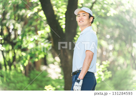 新緑の中でゴルフウェアを着た男性ゴルファー（ゴルフコース・アカデミー・会員権） 131284593