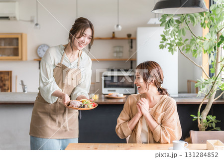 カフェでワンプレートランチを提供,配膳,料理の説明をする店員と女性客 131284852