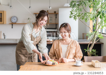 カフェでワンプレートランチを提供,配膳,料理の説明をする店員と女性客 131284853
