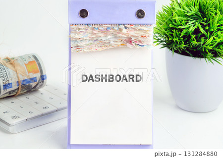 DASHBOARD word written on a desktop calendar on a white background. Analyst working with Financial Report and Business Analytics concept 131284880