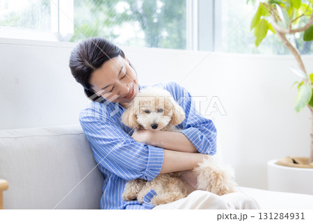 ライフスタイル　リビング　愛犬を抱っこしているミドル女性 131284931