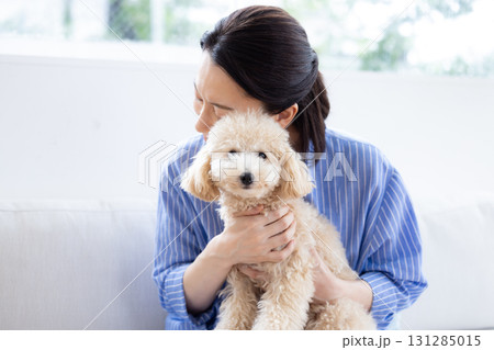 ライフスタイル　リビング　愛犬を抱っこしているミドル女性 131285015