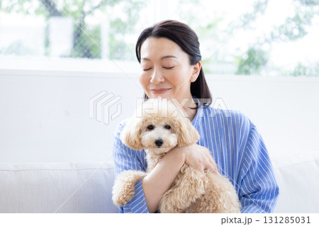 ライフスタイル　リビング　愛犬を抱っこしているミドル女性 131285031