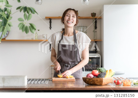 キッチンで料理をする若いアジア人女性（切る,包丁,クッキング,手料理） 131285150