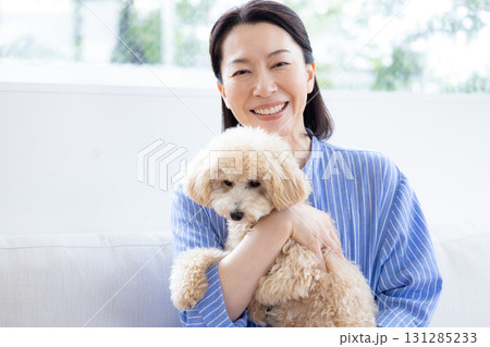 ライフスタイル　リビング　愛犬を抱っこしているミドル女性 131285233