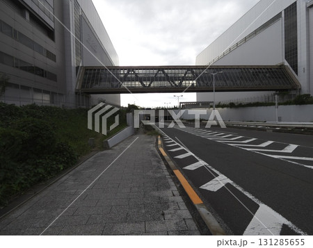 巨大な二棟のビルを繋ぐ連絡通路の下、広い車道と無機質な空間 巨大な二棟のビルを繋ぐ連絡通路の下、広い車道と無機質な空間 131285655
