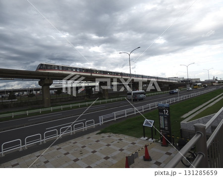 曇天の高架線を走行するモノレールと、空港へ向かう道路、ゲートサイン 131285659