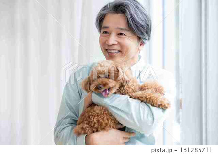 トイプードルを抱っこしているミドル男性 131285711