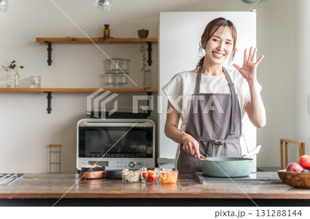 キッチンでお弁当を作る若いアジア人女性 キッチンでお弁当を作る若いアジア人女性 131288144