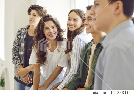 Happy smiling high school student girl looking at camera and smiling standing with her friends. 131288339