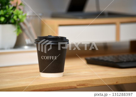 Black paper coffee cup with lid on wooden table in office Black paper coffee cup with lid on wooden table in office 131288397