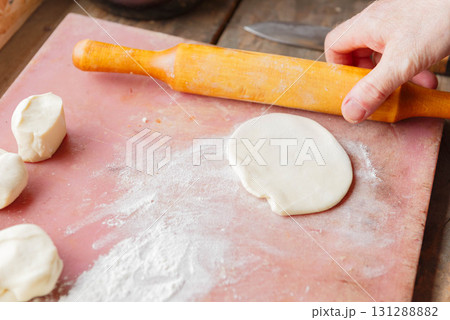 Cutting and rolling out raw dough for baking. pastry chef prepares dough. Cutting and rolling out raw dough for baking. pastry chef prepares dough. 131288882