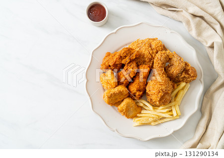 fried chicken with french fries and nuggets on plate 131290134