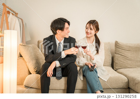 夜,帰宅後にソファに座りながらワインを飲む若いアジア人夫婦,カップル 131290258