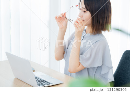 パソコンの前でメガネを掛ける若い女性 131290503
