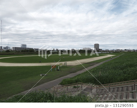 河川敷のグラウンド全景:階段から望む曇り空と都会のビル群 河川敷のグラウンド全景:階段から望む曇り空と都会のビル群 131290593