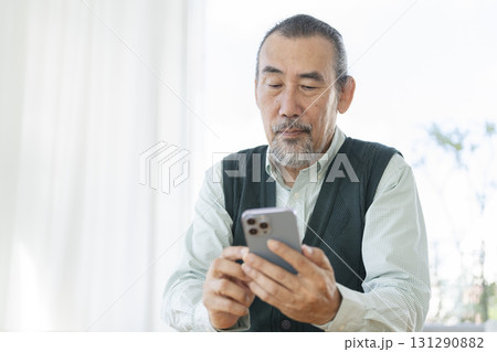 スマートフォンを操作するシニア男性 スマートフォンを操作するシニア男性 131290882