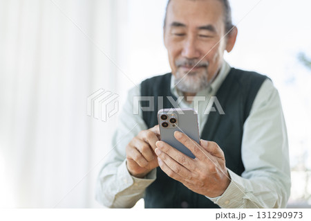 スマートフォンを操作する70代の男性の手元 131290973