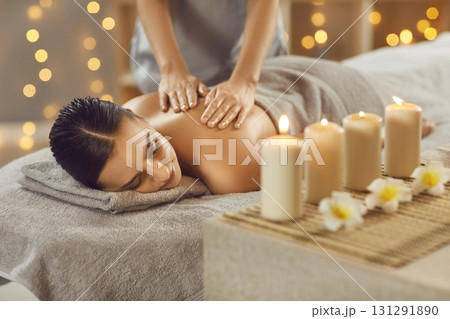 Young woman relaxing in spa salon with hot stones along spine 131291890