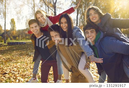 Portrait of friends who are having fun and laughing while walking in park on sunny autumn day. 131291917