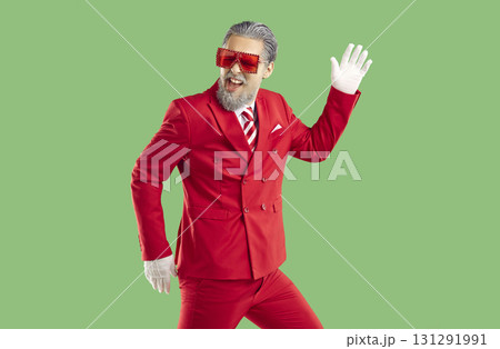 Santa Claus fooling around and dancing with his hand raised on isolated green background. 131291991
