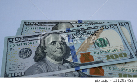 Women's hands place hundred-dollar bills on the table, one on top of the other 131292452