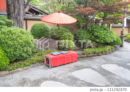 Traditional Japanese garden bench with red umbrella in peaceful outdoor setting at Tokyo, Japan Traditional Japanese garden bench with red umbrella in peaceful outdoor setting at Tokyo, Japan 131292870